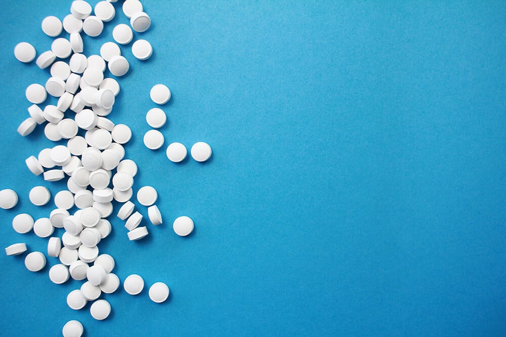 White pills on blue background